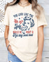 Model wearing natural color shirt with 'You Look Like The 4th Of July' graphic design